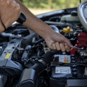 Man is Checking car battery because car battery is depleted. concept car maintenance
